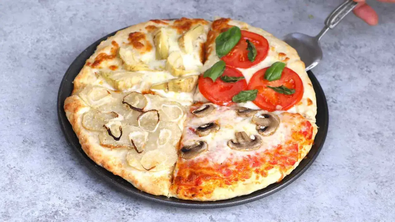 Une pizza quattro stagioni aux artichauts, tomates, oignons et champignons, pr&ecirc;te &agrave; &ecirc;tre servie.