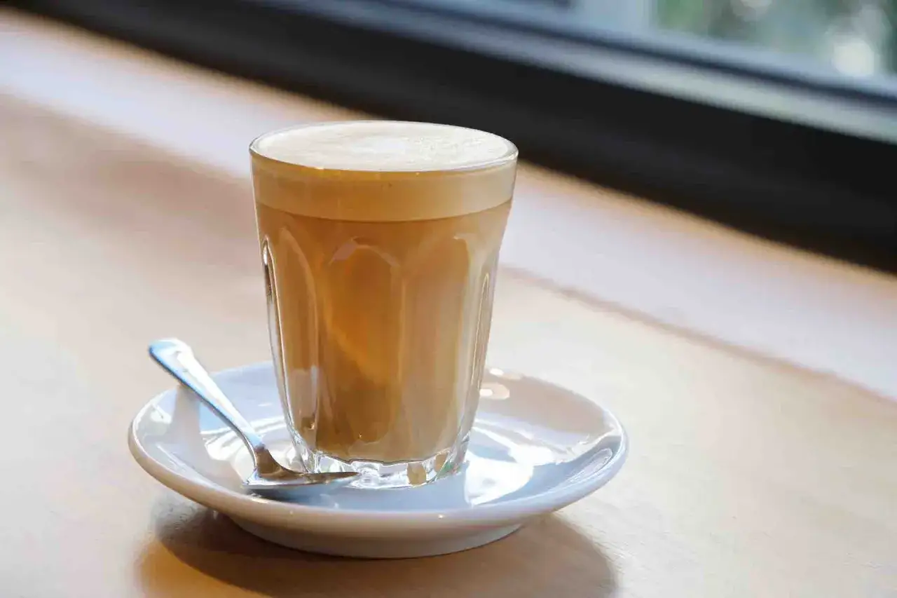Un bicchiere di caff&egrave; latte con schiuma cremosa, pronto per essere gustato. Ecco come si fa un caff&egrave; latte perfetto.