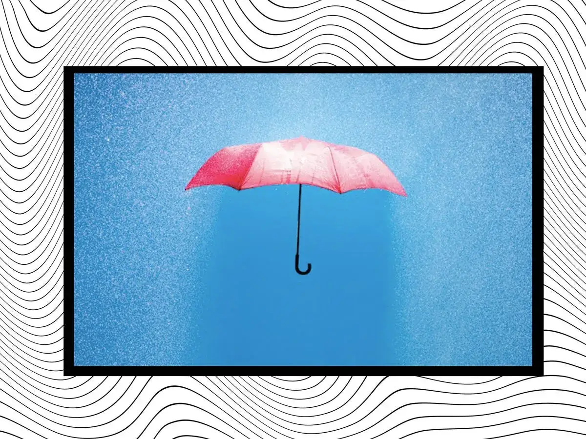 Un paraguas rosa flota en el cielo azul, rodeado de gotas de lluvia. Es como soñar con paraguas, una imagen surrealista y mágica.
