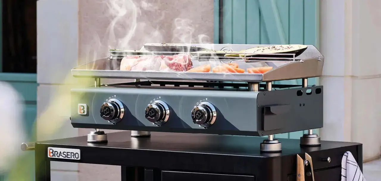 Viande et légumes cuisent sur une plancha Brasero fumante. Le nettoyage de la plancha Brasero sera facile après ce festin.