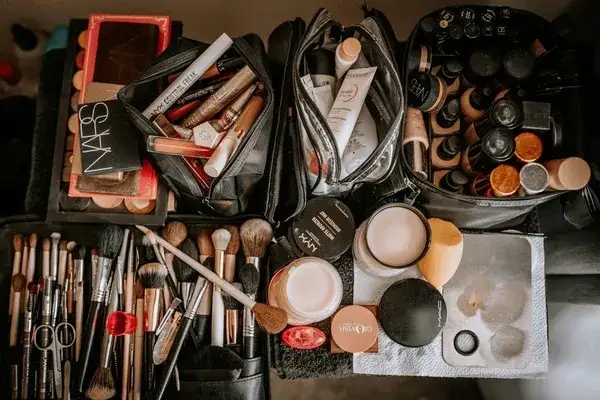 Flatlay mit verschiedenen Kosmetikprodukten wie Lippenstift, Puder und Mascara