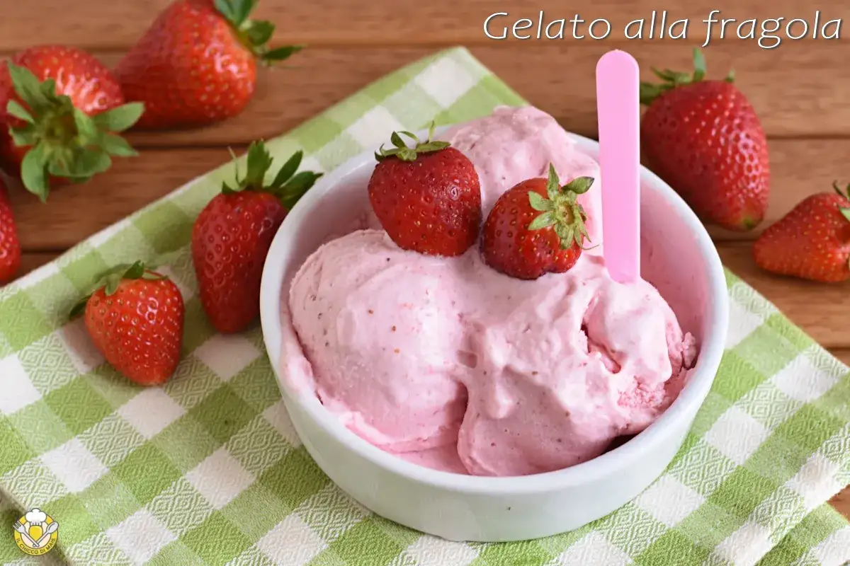 Delizioso gelato fatto in casa alla fragola, guarnito con fragole fresche, su una tovaglietta a quadretti verdi.