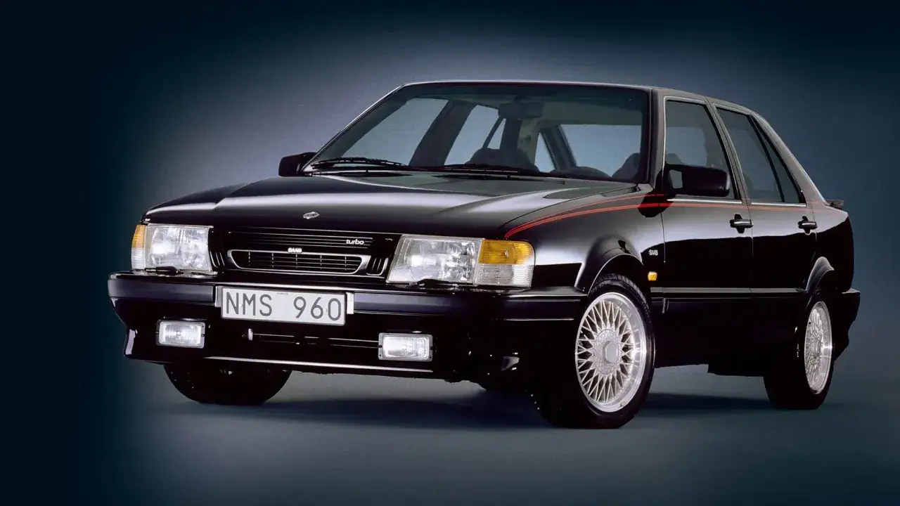 Svart Saab 9000 CD Turbo med röda detaljer. En klassisk svensk sedan som utstrålar stil och prestanda.