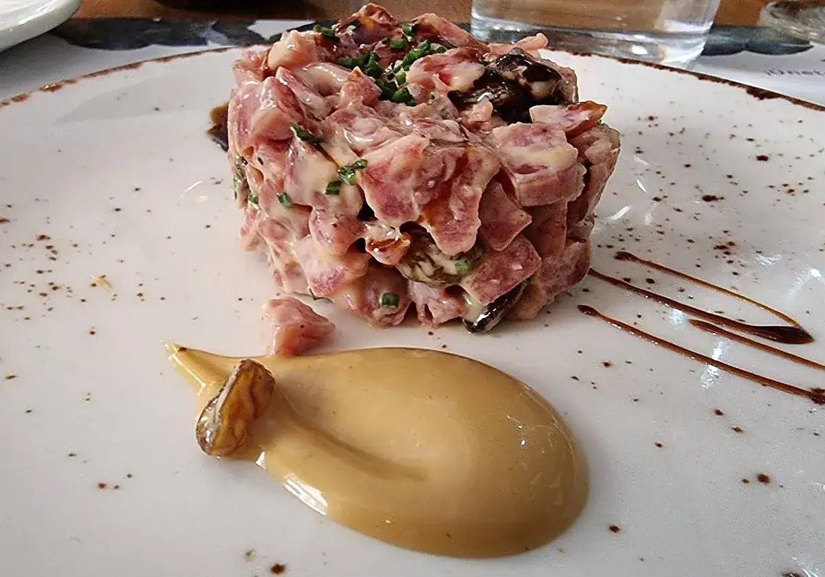 Tartar de salchich&oacute;n con salsa cremosa y un toque de cebollino. Los ingredientes se ven frescos y listos para disfrutar.