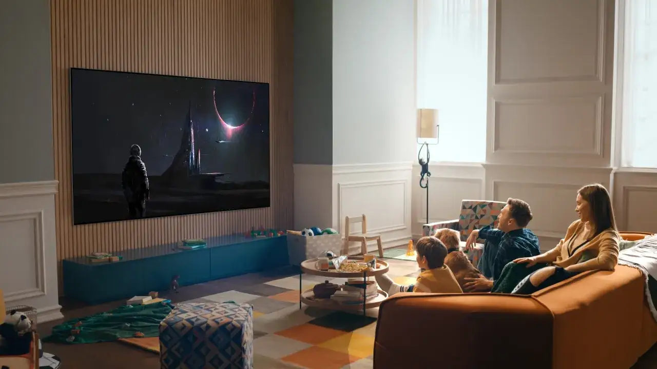 Familjen njuter av en film p&aring; TV:n, med ett rymd&auml;ventyr p&aring; sk&auml;rmen. Ett bekv&auml;mt avst&aring;nd tv soffa ger den perfekta utsikten.