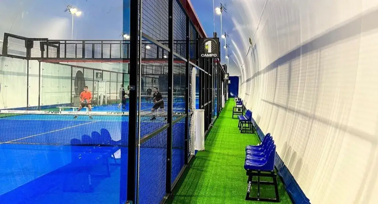 Campi da padel indoor con giocatori in azione. L'atmosfera è quella di un torneo di **Europa Padel**, con tribune pronte ad accogliere il pubblico.