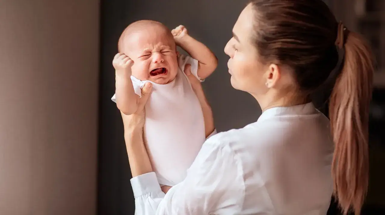 Mutter hält ihr weinendes Baby. Manchmal fühlt sie: ich hasse mein Baby wenn es schreit.