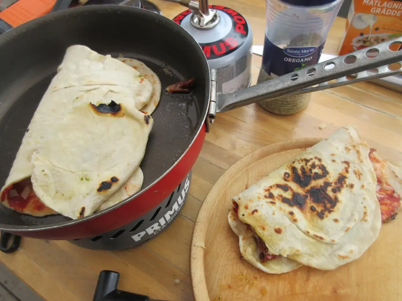 Två fyllda tortillas steks i en stekpanna över en gasbrännare. Perfekt för friluftsmat recept.