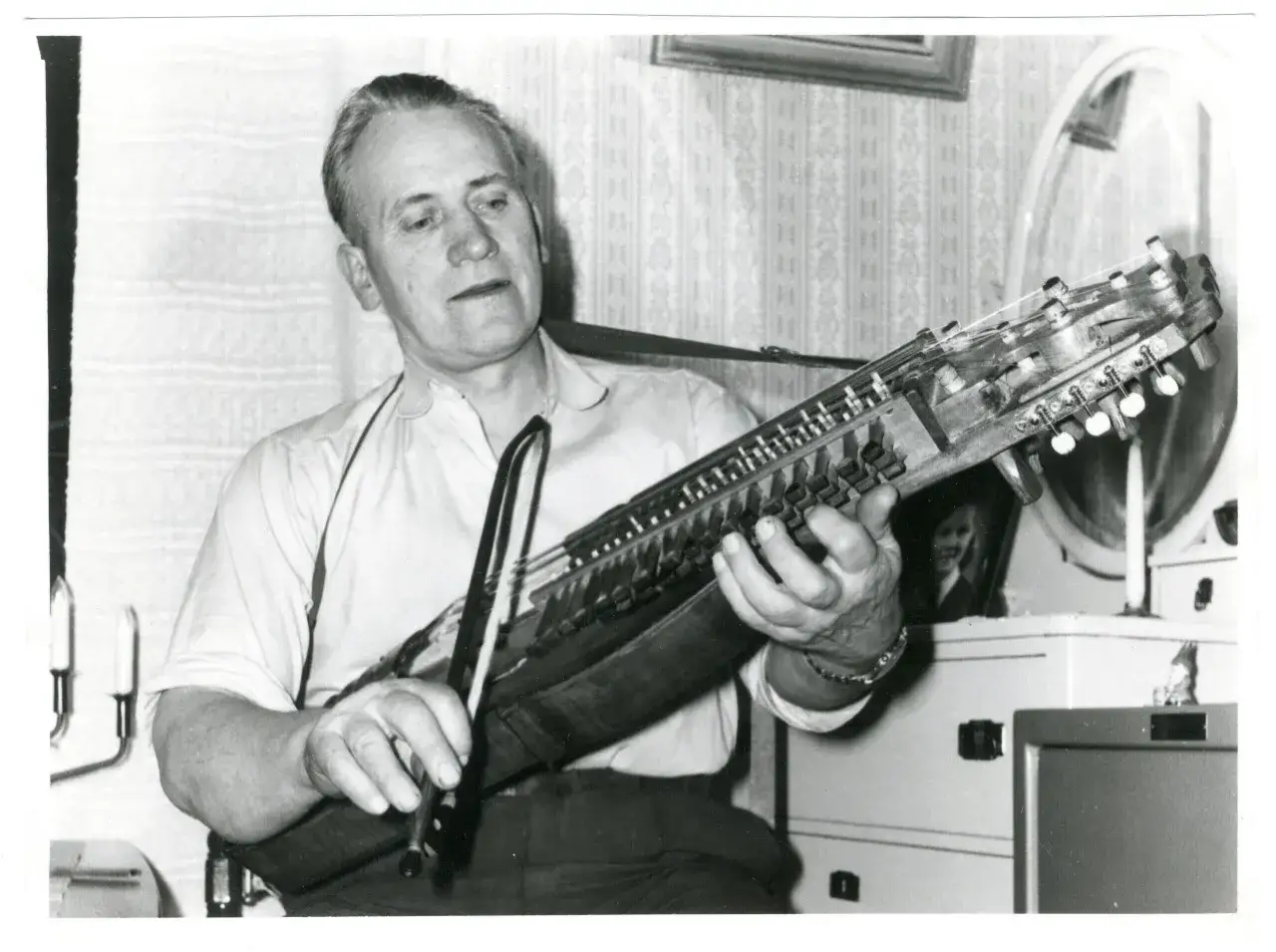 Man spelar nyckelharpa, ett instrument som hör hemma på ett musik museum.