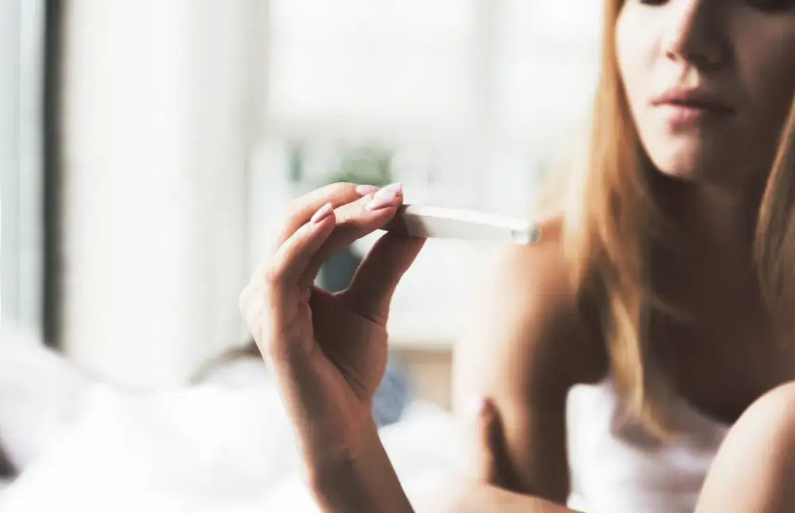kobieta wykonująca test ciążowy w domu