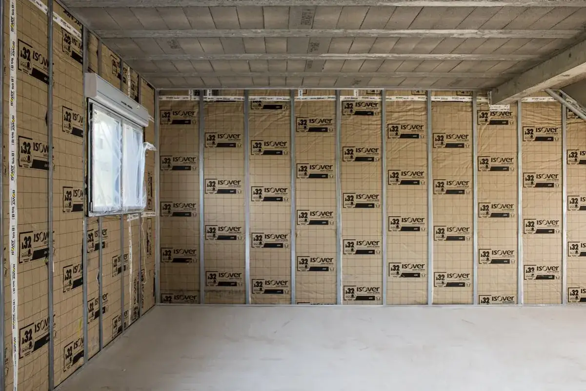 Isolation d'un mur de maison en cours, montrant l'épaisseur du mur avec des panneaux isolants.