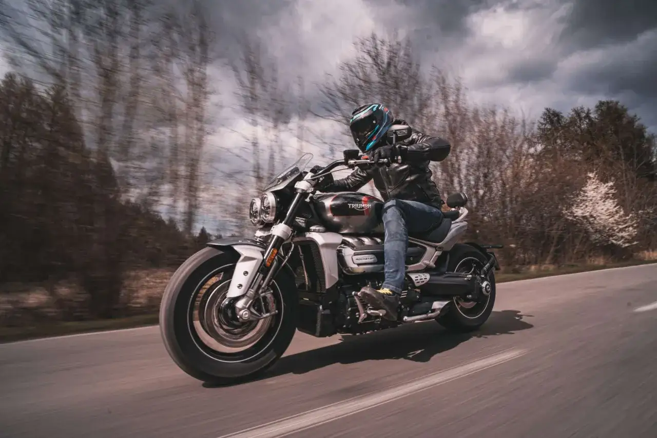 Motocyklista w kasku i skórzanej kurtce pędzi na motocyklu Triumph Rocket 2.