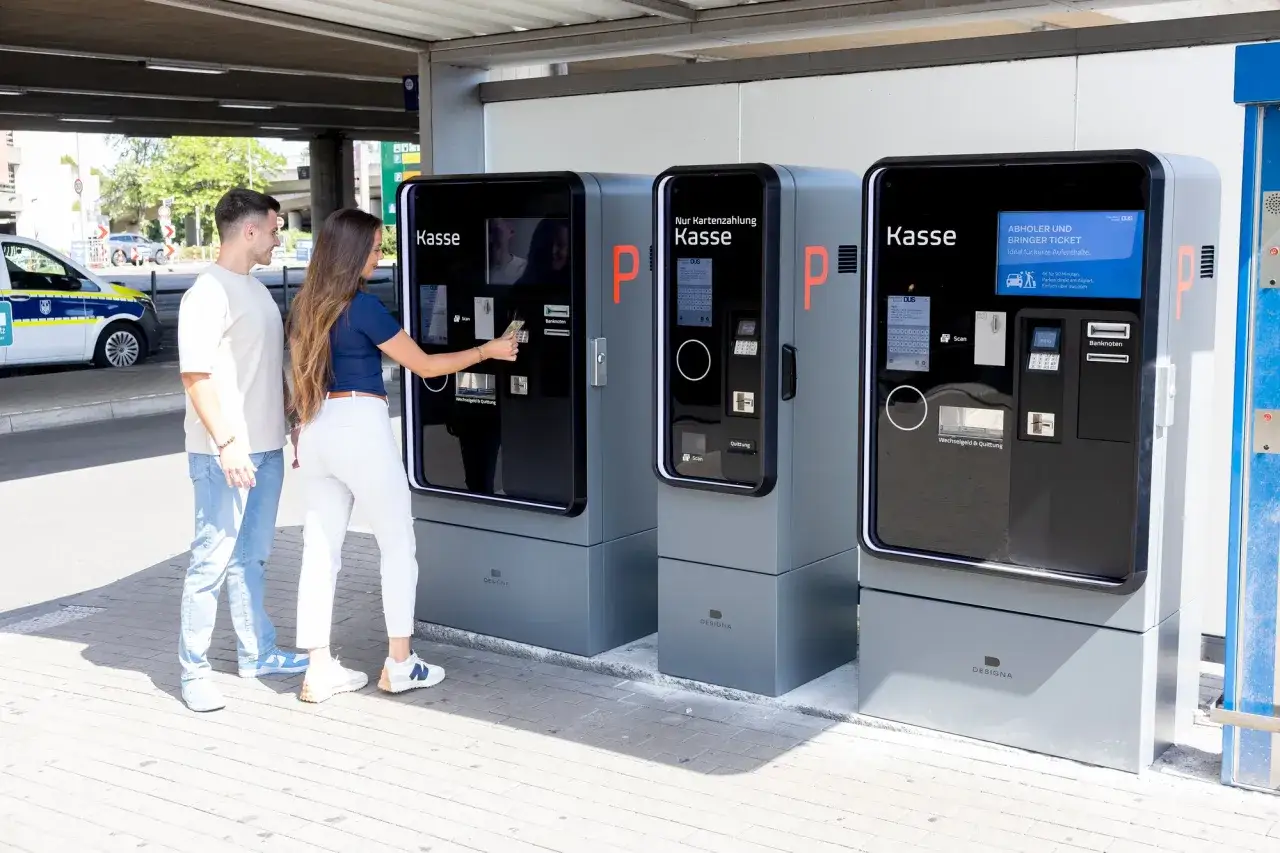 Para dowiedzieć się, ile kosztuje parking na lotnisku w Düsseldorfie, korzysta z automatu do płatności.