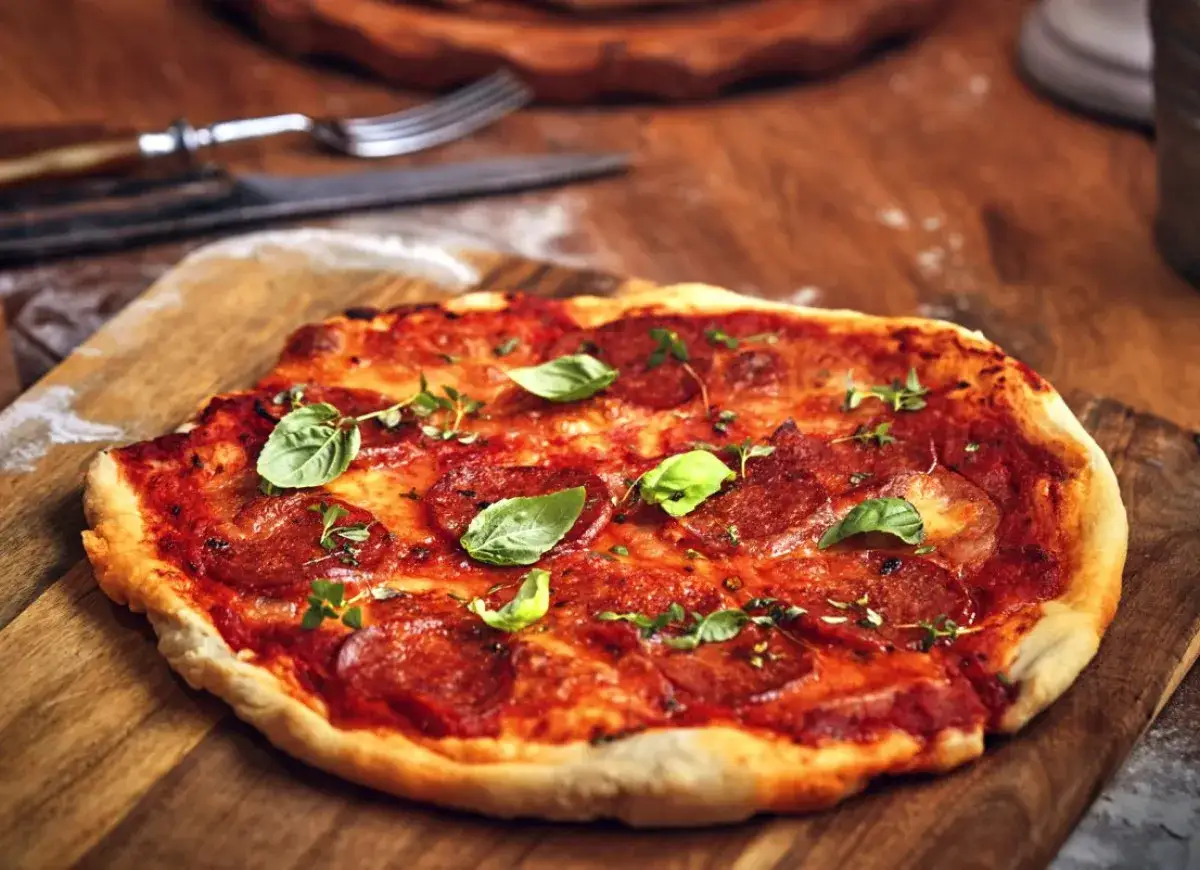 Pizza z salami, pomidorami i świeżą bazylią. Idealne dodatki dla miłośnik&oacute;w klasyki.