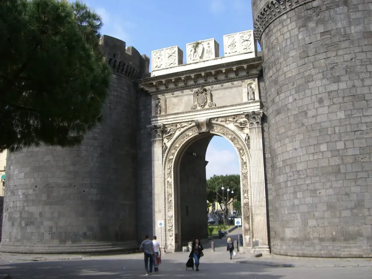 Le porte di Napoli storiche, un imponente arco trionfale tra torri massicce, accoglie i visitatori con la sua maestosità.