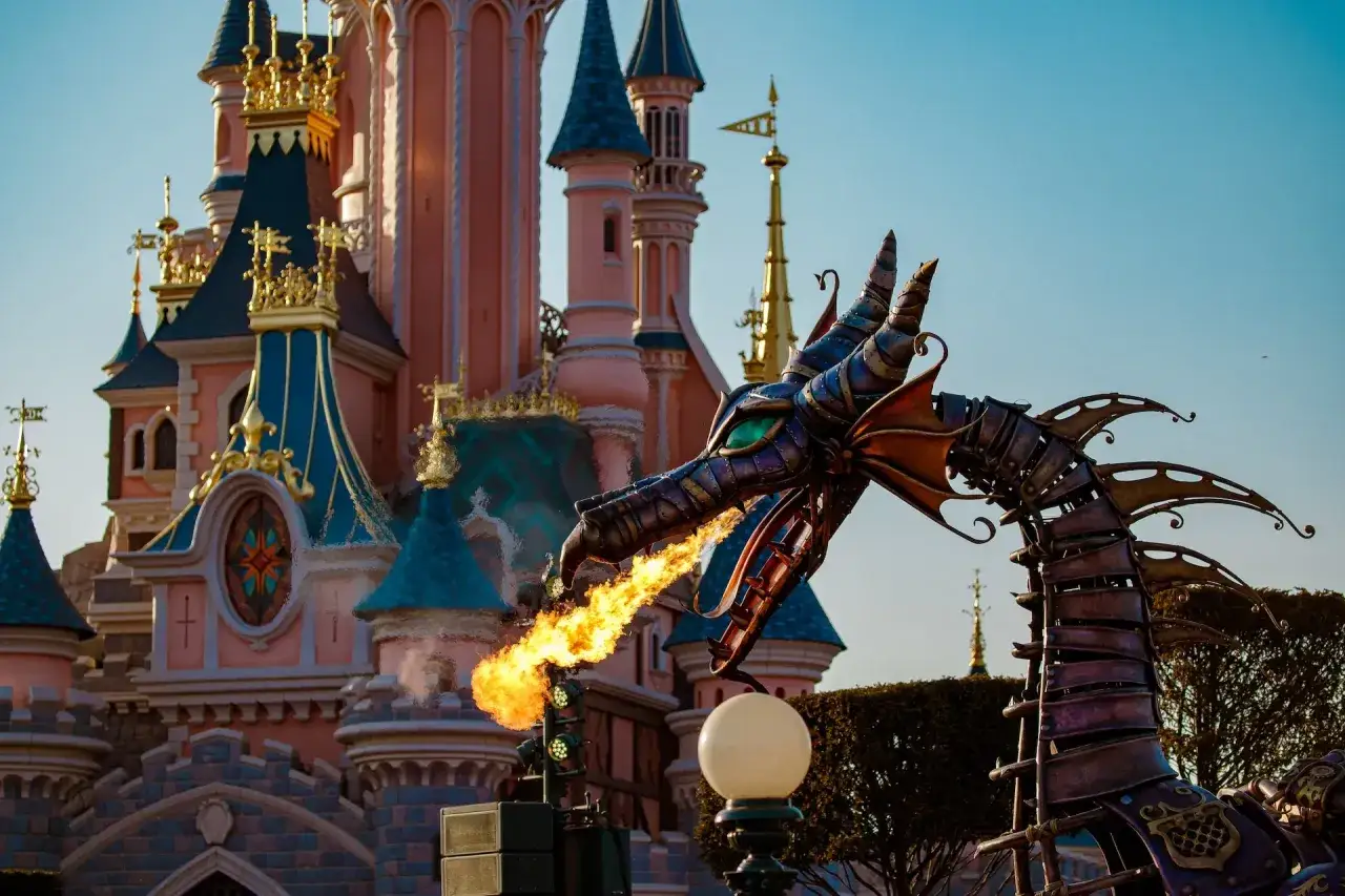 Smok zieje ogniem przed zamkiem w Disneylandzie. Warto sprawdzić, ile kosztuje Disneyland, by zobaczyć takie widowisko!