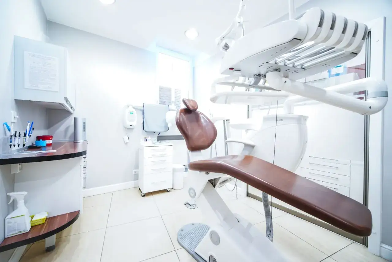 Nowoczesny gabinet stomatologiczny ze sprzętem i fotelem dentystycznym.