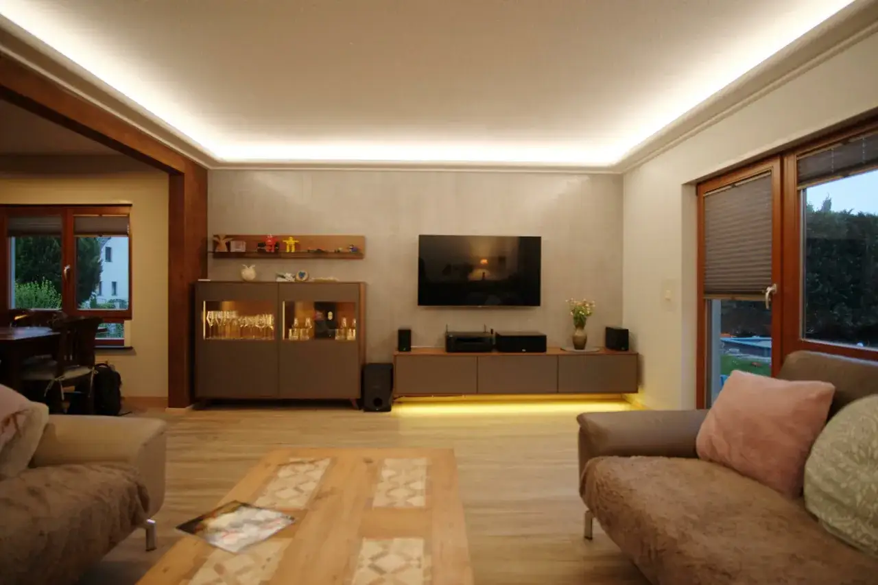 Gemütliches Wohnzimmer mit moderner Beleuchtung, großem Fernseher und stilvollen Möbeln – pure Inspiration wohnen.
