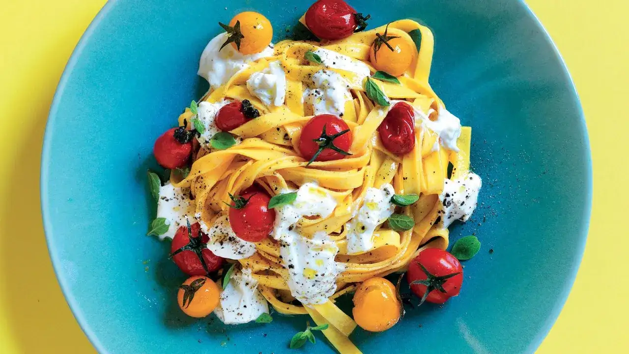 Pasta fresca con pomodorini ciliegino, burrata cremosa e basilico fresco, un piatto estivo da gustare.