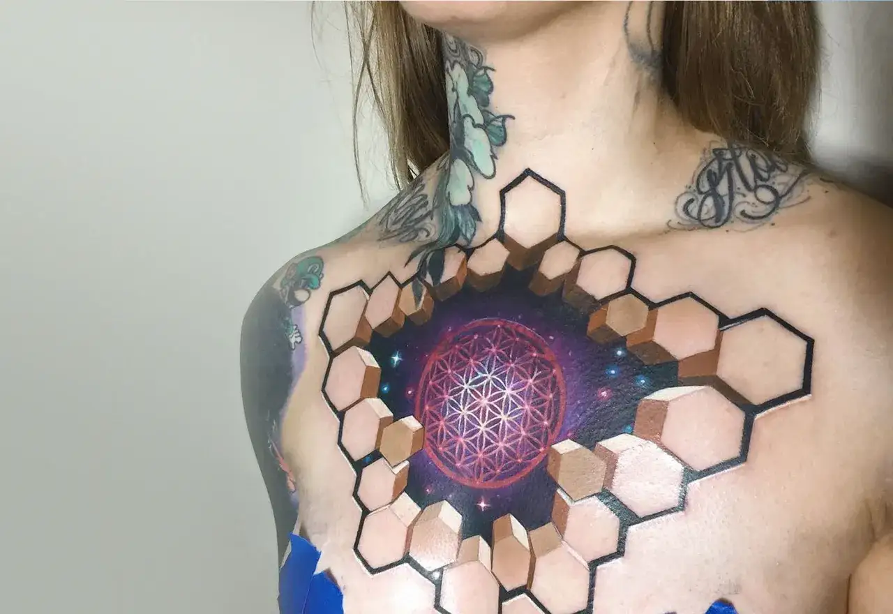 Un impresionante tatuaje 3D en el pecho, con un diseño geométrico que se abre a un cosmos estrellado.