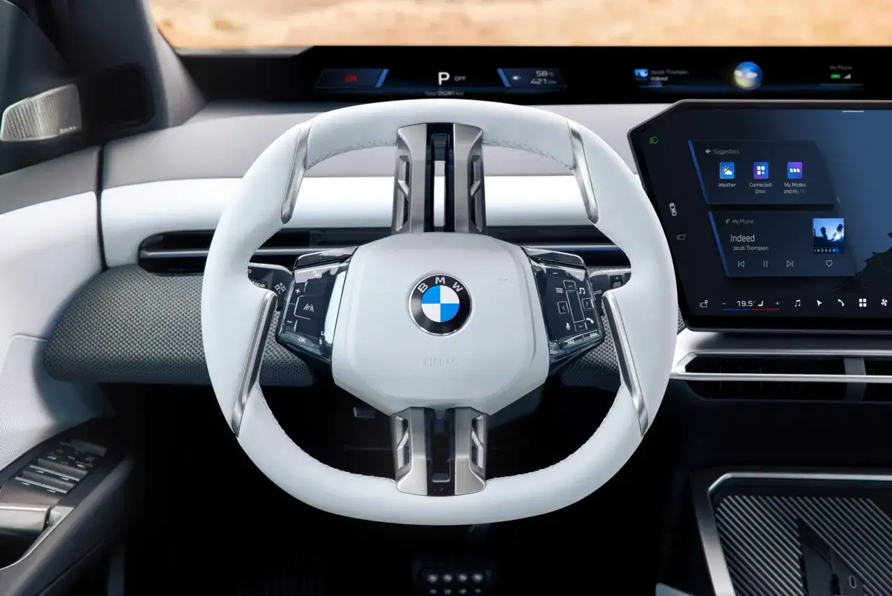 Volante bianco della BMW Neue Klasse, con display digitale e logo BMW.