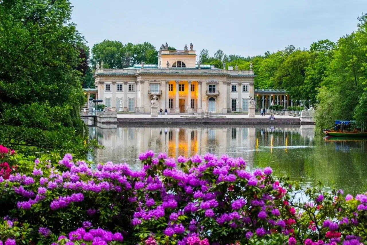 Piękny Pałac na Wyspie w Łazienkach Królewskich w Warszawie, otoczony wodą i kwitnącymi rododendronami.