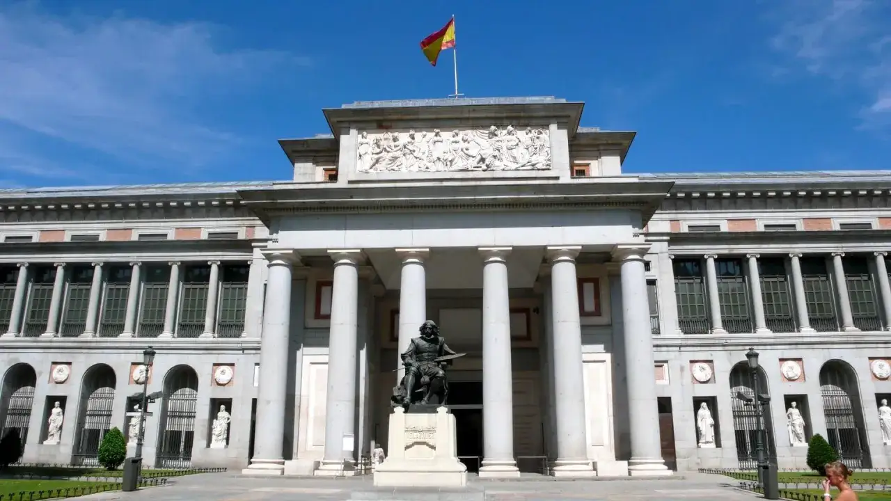 Przed imponującym muzeum sztuki w Madrycie, z hiszpańską flagą na dachu, stoi pomnik artysty.