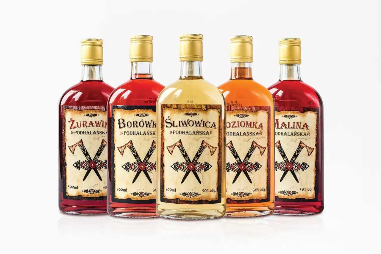 Pięć butelek z nalewkami: żurawinowa, borówkowa, śliwowa, ożonowa i malinowa. Etykiety z motywem toporów i napisem
