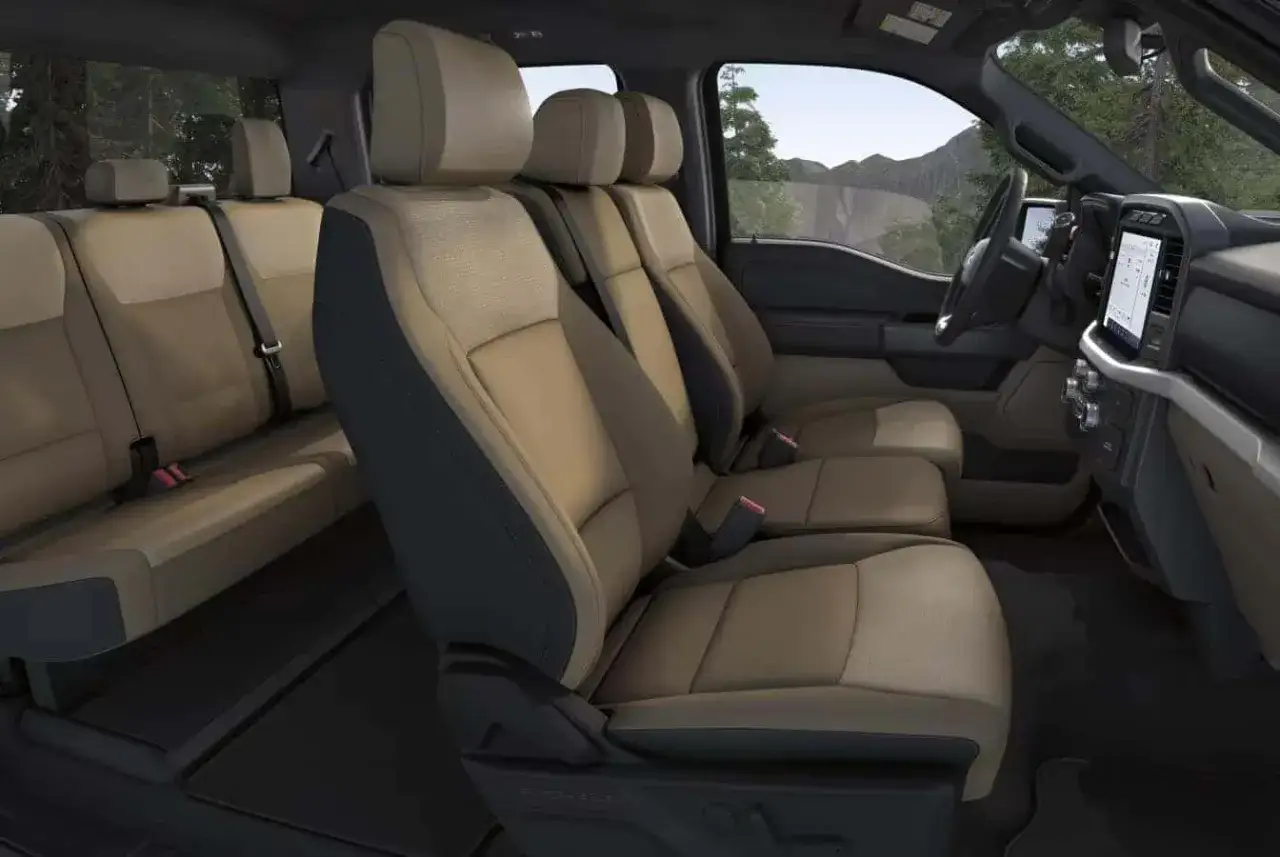 Int&eacute;rieur d'un camion Ford, avec des si&egrave;ges confortables en cuir beige et gris. Parfait pour les longs trajets.