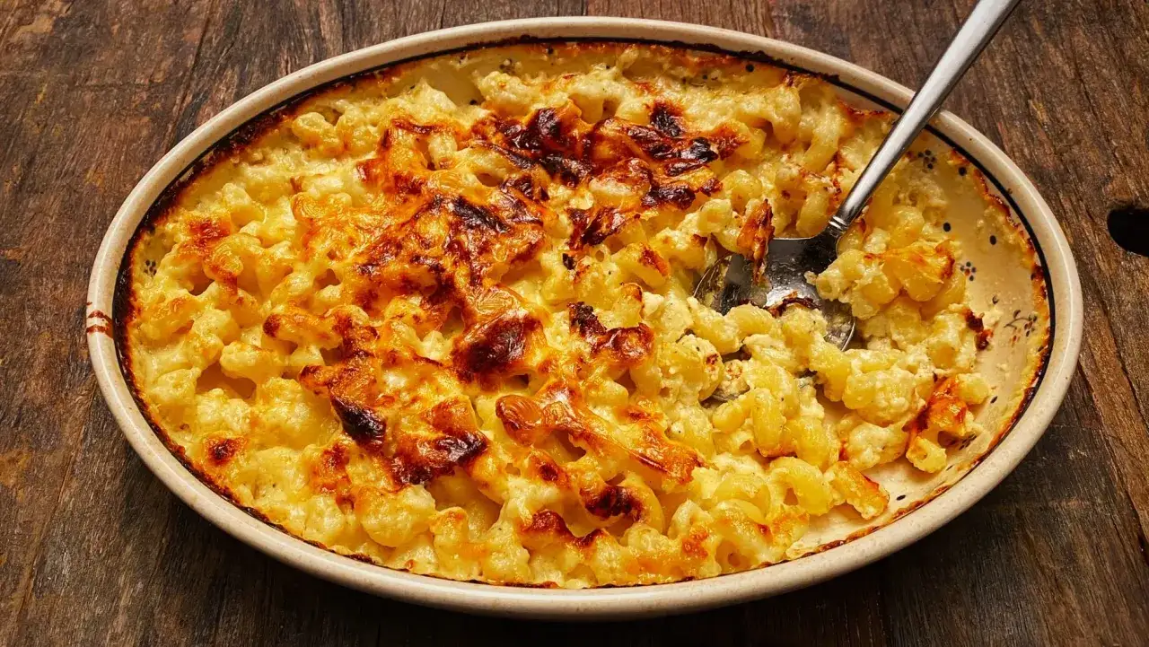 Zapiekane mac and cheese w ceramicznym naczyniu, z chrupiącą, złotą sk&oacute;rką serową. Idealne na rodzinny obiad.