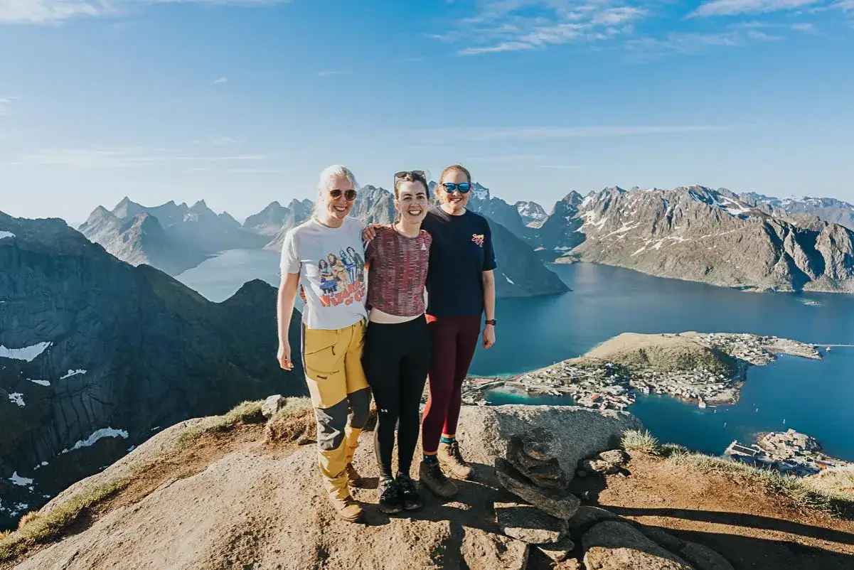 Trzy przyjaciółki na szczycie góry w Norwegii. Warto zabrać do Norwegii ciepłe ubrania i dobre buty, bo pogoda bywa zmienna.