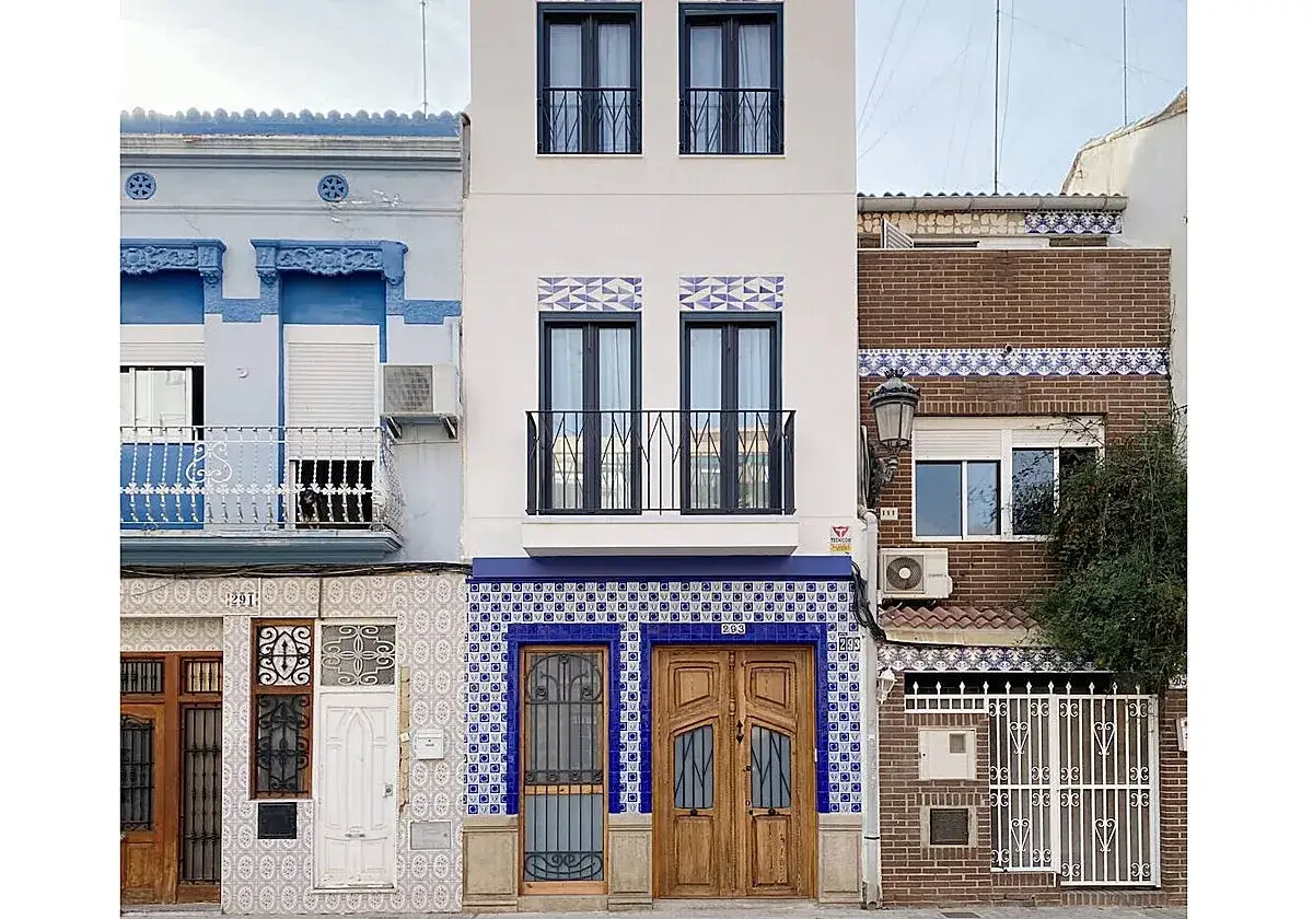 Fachadas de casas con azulejos de estilo art déco en tonos azules y blancos, y puertas de madera.