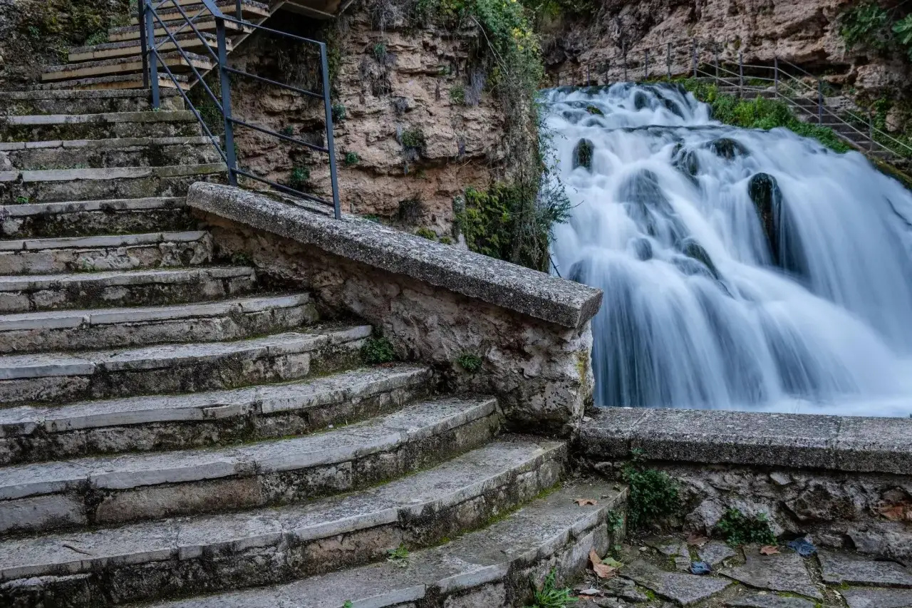Escaleras de piedra desgastada conducen a las impresionantes trillo cascadas, un espectáculo natural de agua en movimiento.