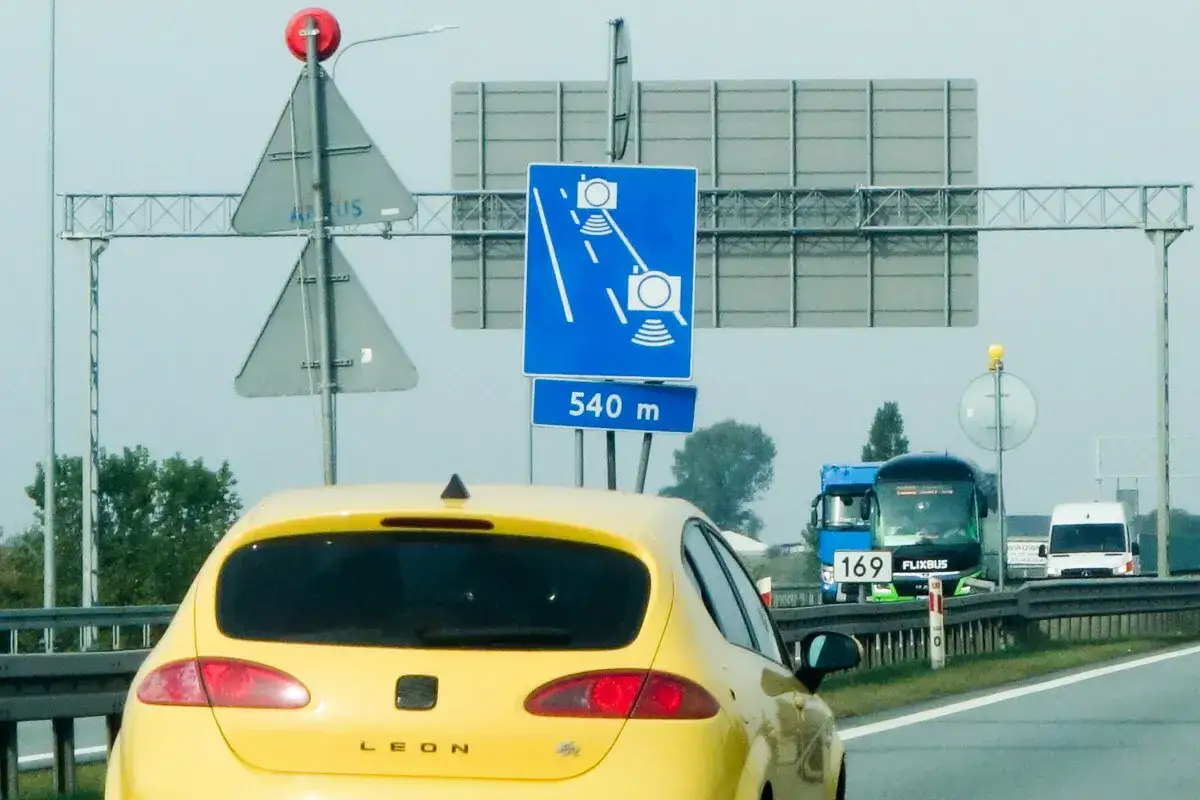 Znak informuje o odcinkowym pomiarze prędkości na dystansie 540 m. W tle autobus Flixbus i inne pojazdy.