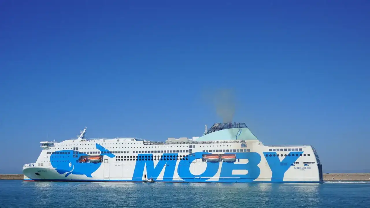 El ferry Moby Legacy, con su ic&oacute;nico dise&ntilde;o de ballena azul, navega rumbo a Cerde&ntilde;a o Sicilia bajo un cielo despejado.