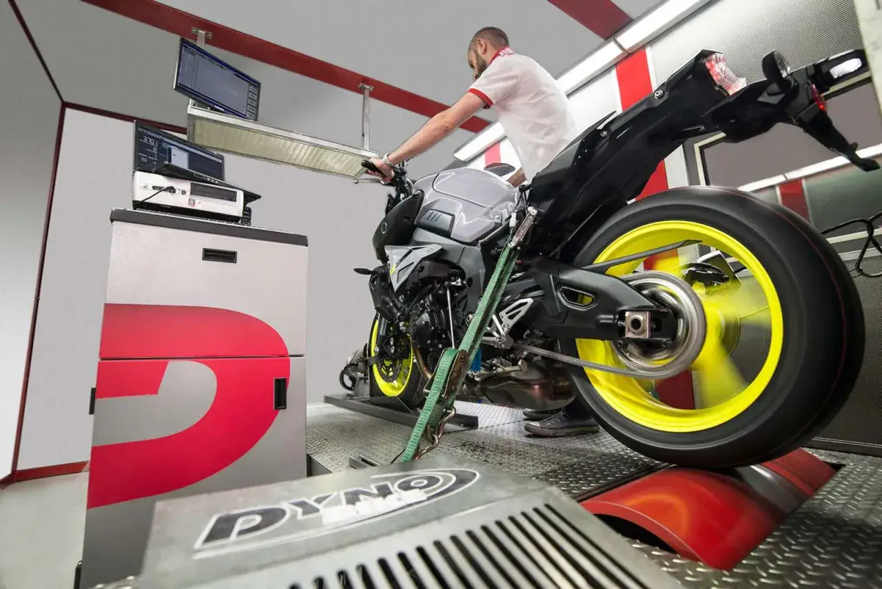 Un mec&aacute;nico ajusta una moto en un dinam&oacute;metro, listo para ver c&oacute;mo se puede reprogramar una moto y optimizar su rendimiento.