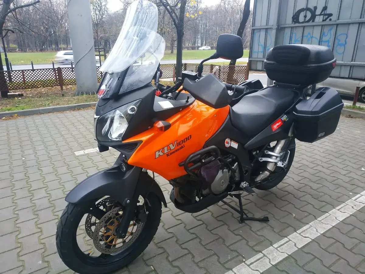 Pomarańczowy motocykl turystyczny Kawasaki KLV 1000 z kuframi, gotowy na przygodę.