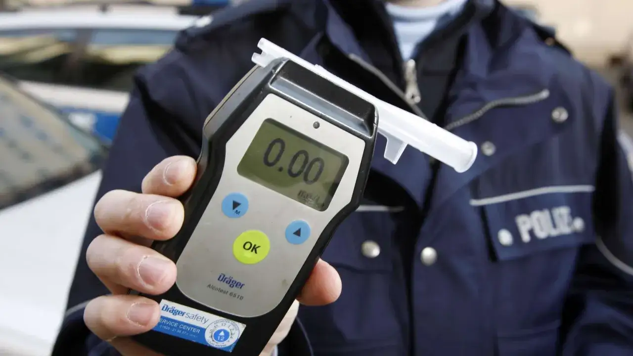 Polizist hält Atemalkoholtestgerät. Null Promille. Kein Alkohol am Steuer, auch nicht in Spanien.