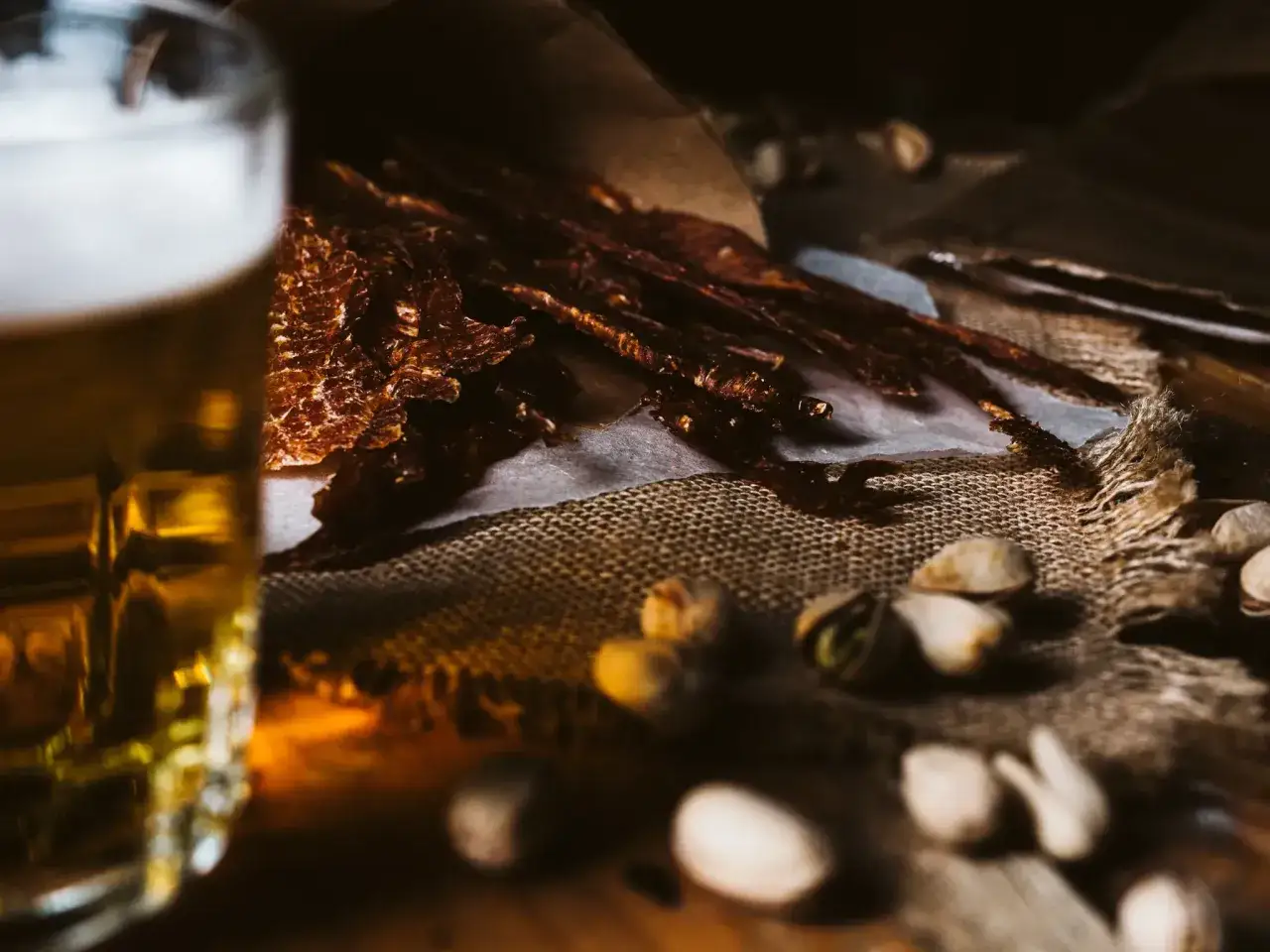 Szklanka piwa i pyszne, suszone plastry wołowiny, idealne do piwa. Ta beef jerky marynata to prawdziwy przysmak.