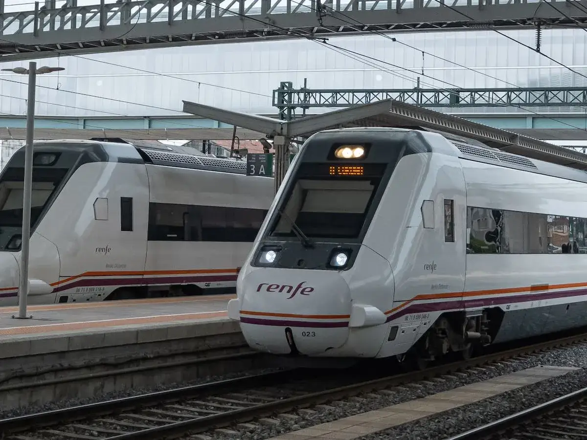 Dos trenes Renfe esperan en la estaci&oacute;n. Uno de ellos, con el n&uacute;mero 023, se dirige a Sarria, partiendo de Santiago.