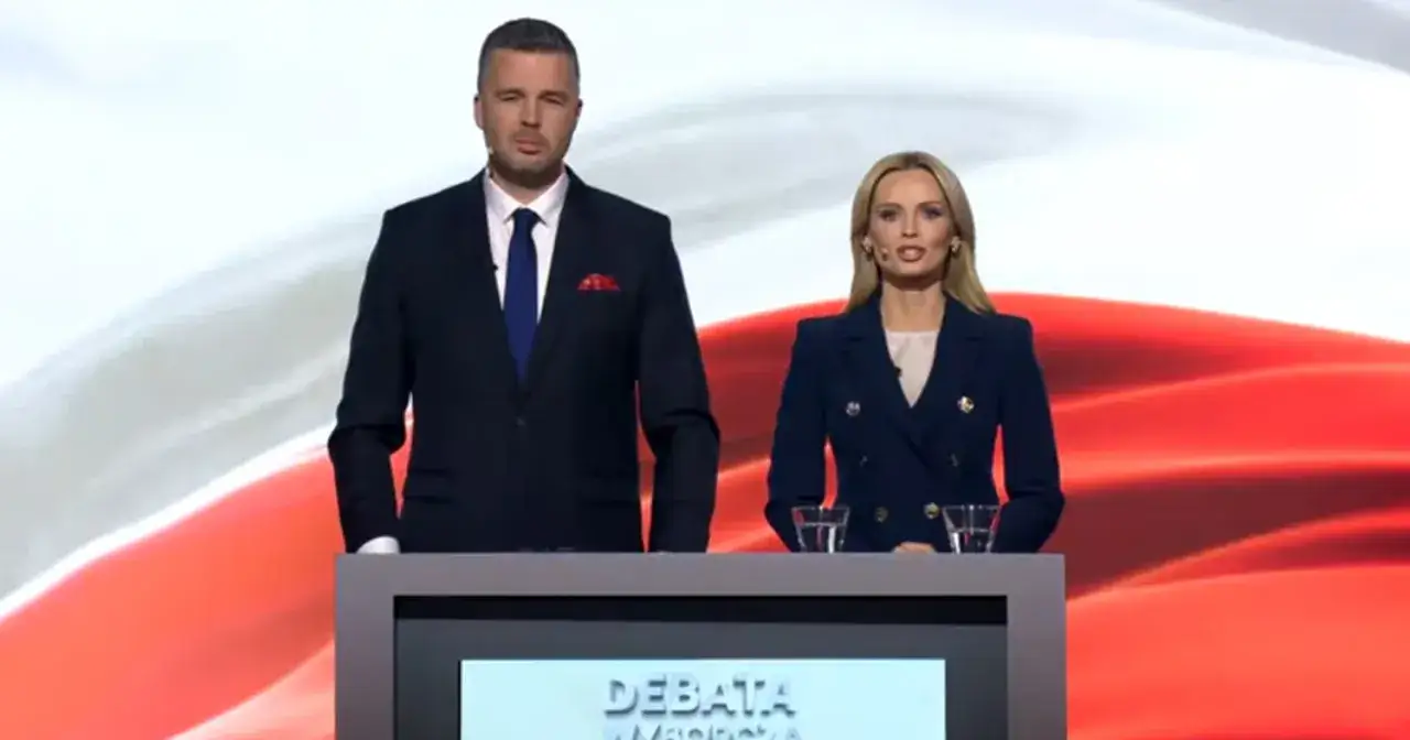 Mężczyzna i kobieta w eleganckich strojach stoją za mównicą. To debata polityczna, gdzie partie prezentują swoje programy.