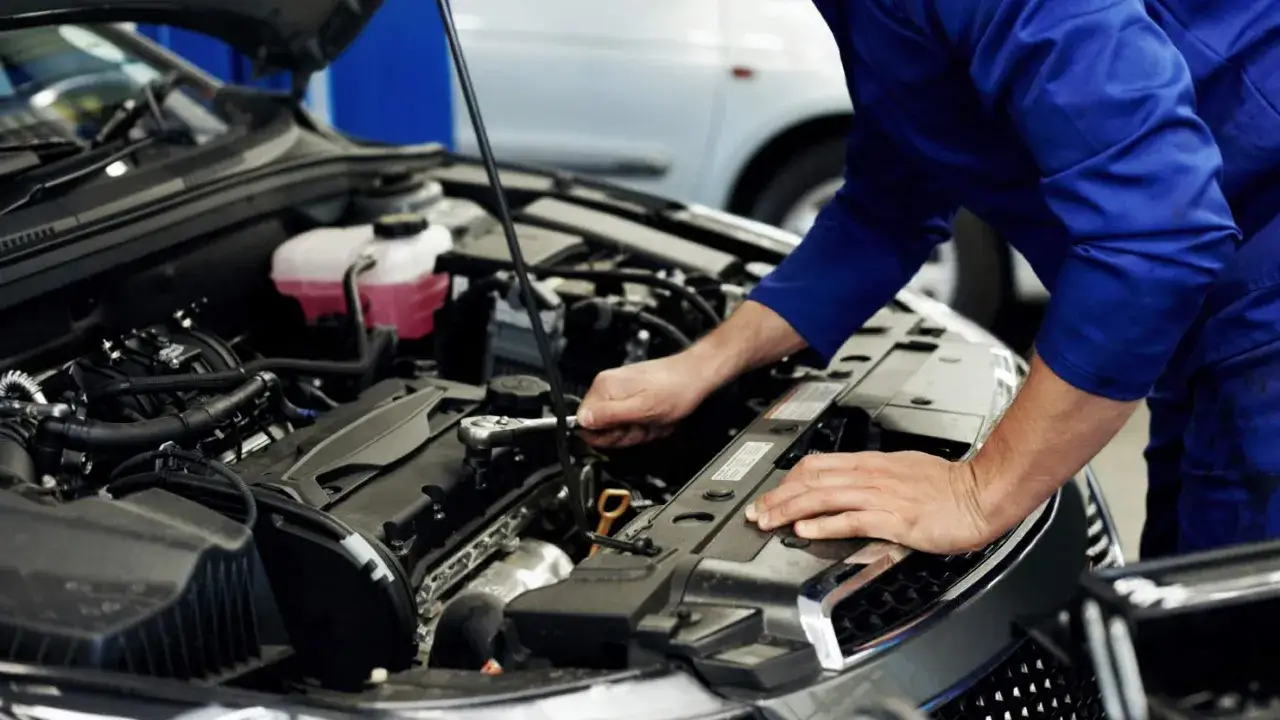 Mécanicien travaillant sur un moteur de voiture. Obtenez un devis pour le prix du diagnostic de votre voiture.