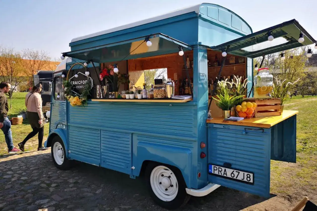 Niebieski food truck z napisem 