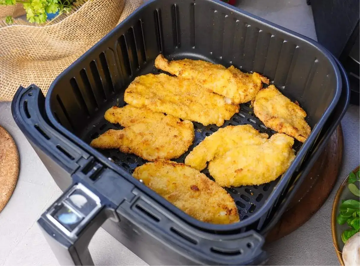 Goldbraunes Schnitzel im Airfryer, bereit für den Genuss. Knusprig und lecker, die perfekte Mahlzeit für schnelle Küche.