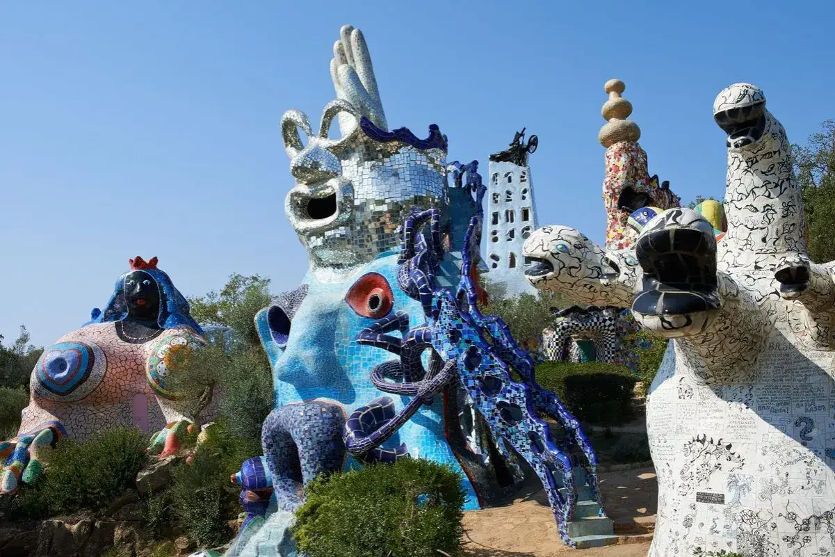 Esculturas coloridas y fantásticas del Jardín de Tarots de Niki de Saint Phalle, con figuras humanas y animales cubiertas de mosaicos.