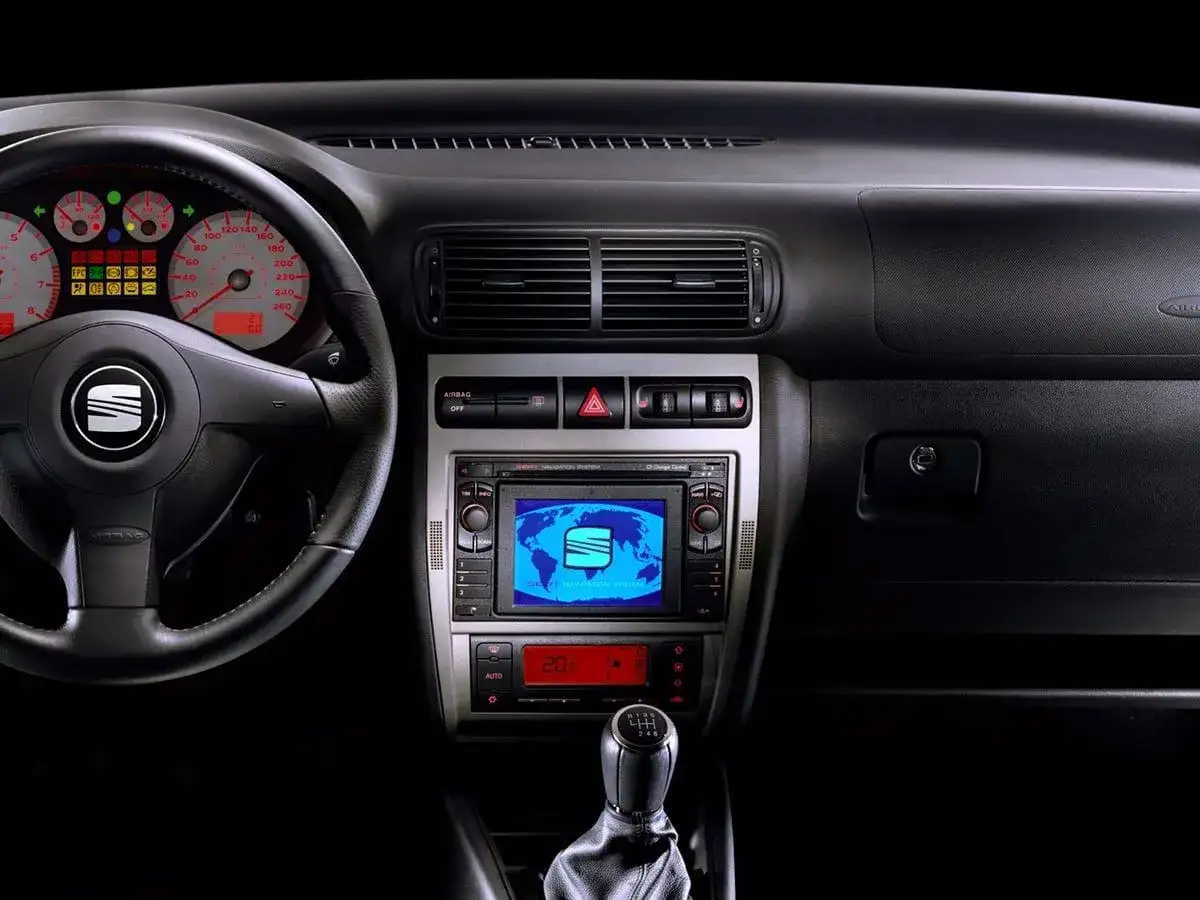 Wnętrze Seat Leon 2000: kierownica, zegary, radio z nawigacją i dźwignia zmiany biegów.