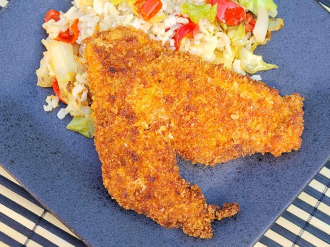 Chrupiący kotlet w panierce panko, podany z ryżem i warzywami. Panko co to? To japońska bułka tarta, która nadaje potrawom niezwykłą lekkość i chrupkość.