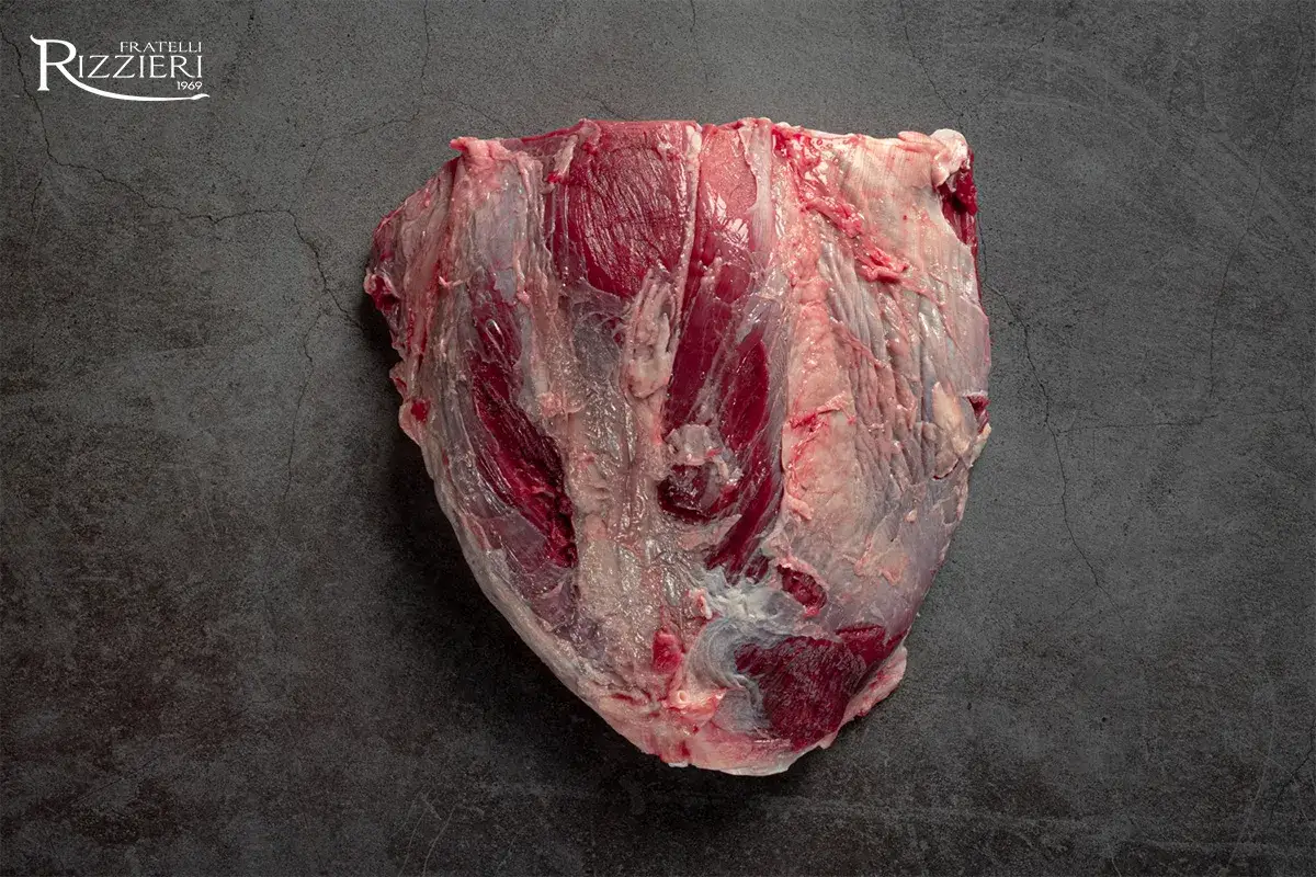 Un pezzo di carne cruda, succulenta e di alta qualità, proveniente da animali grass fed, su sfondo scuro.