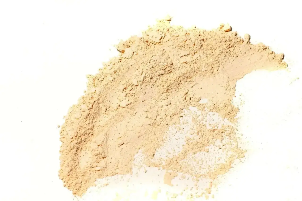 Feiner, beiger Puder, der wie **Caesalpinia spinosa gum** aussieht, liegt auf wei&szlig;em Hintergrund.
