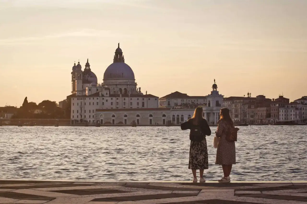 Deux amies contemplent la basilique Santa Maria della Salute, un moment paisible à Venise en octobre.